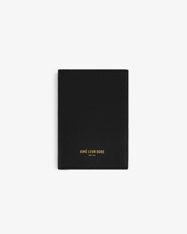 A black Leather Passport Holder with AIMÉ LEON DORE in gold at the bottom center.