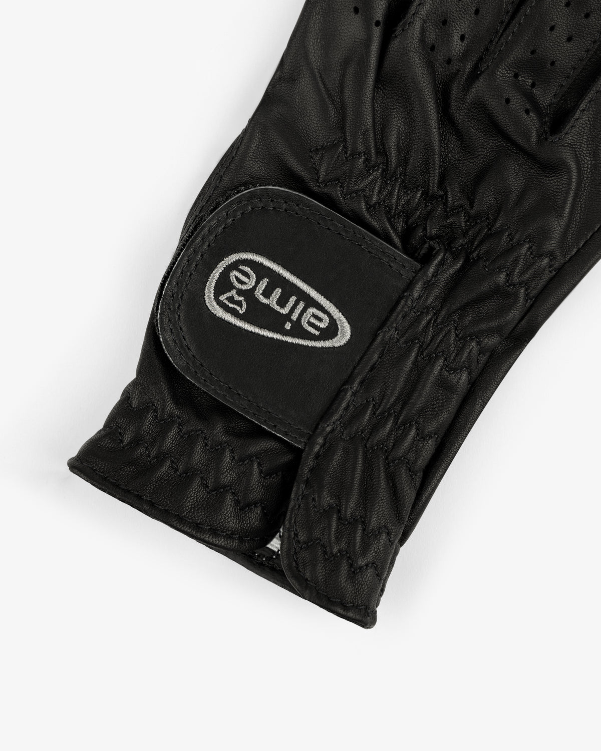 A close-up of the ALD / FootJoy StaSof Heritage Glove (Right) in black leather with a velcro strap labeled "aimé.