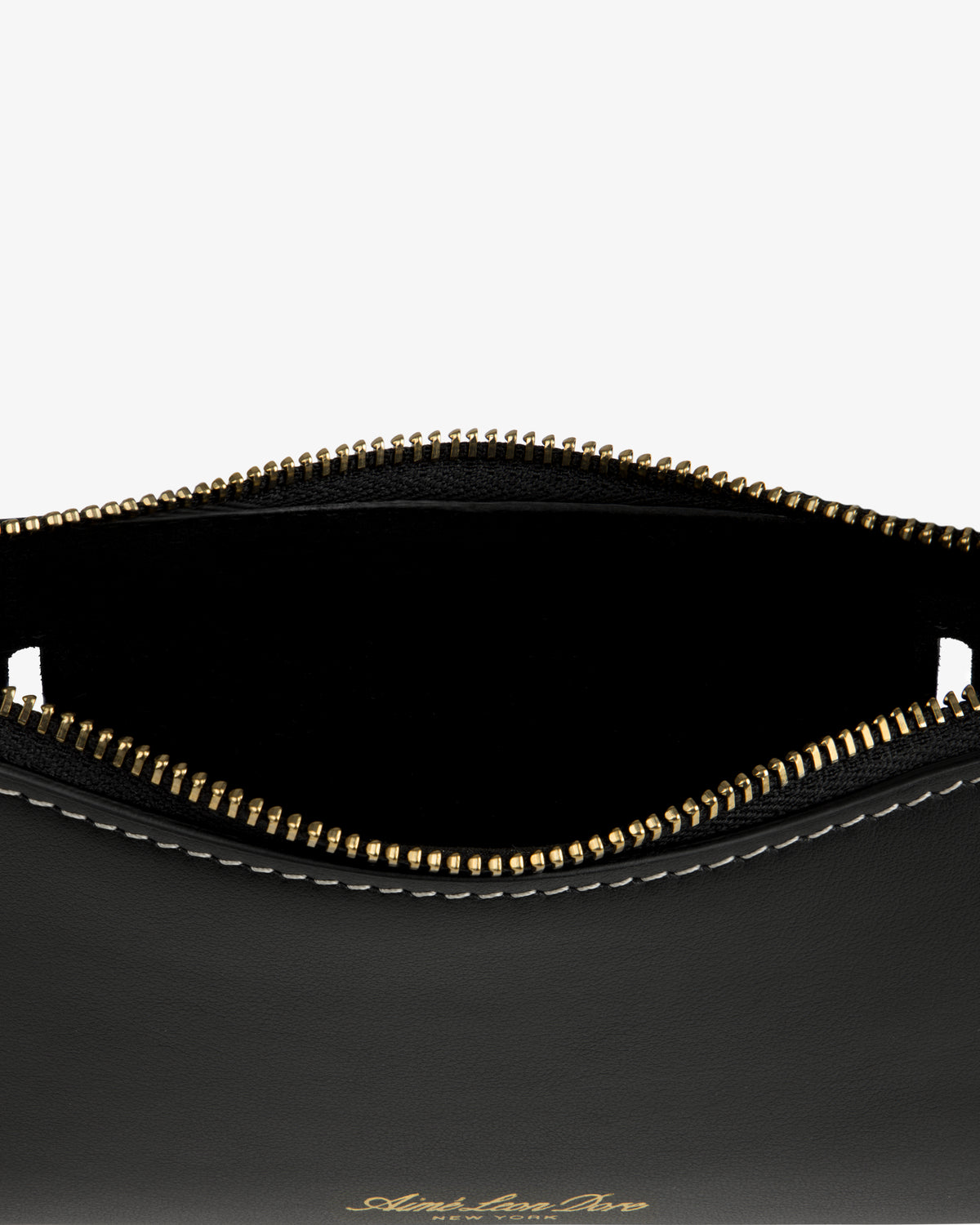 Close-up of the Convertible Leather Belt Bag: open black leather pouch with gold zipper, white stitching, and empty interior.