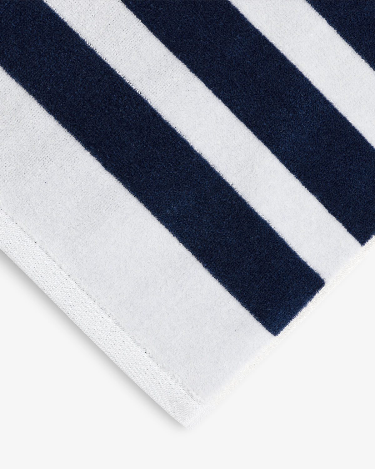 A close-up of the Striped Beach Towel featuring thick navy blue and white stripes.