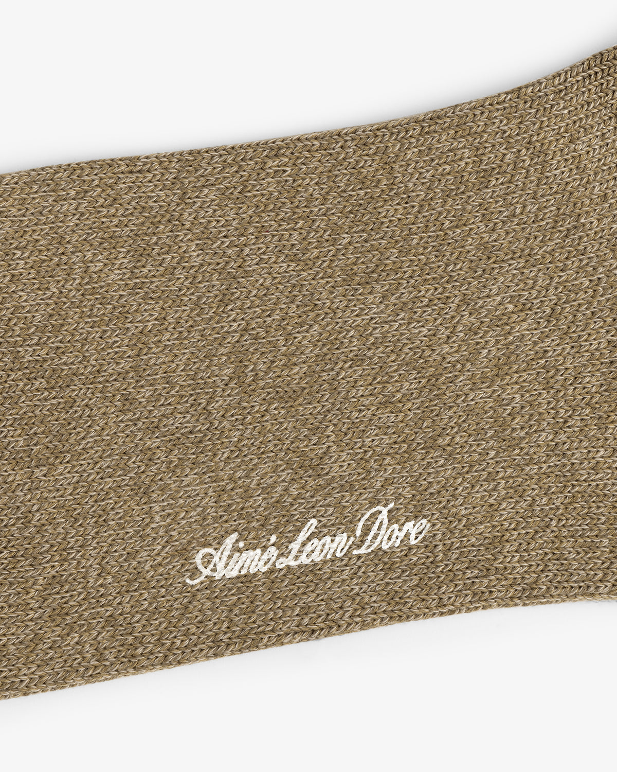 Close-up of brown knit Marled Quarter Sock with Aimé Leon Dore embroidered in white cursive.