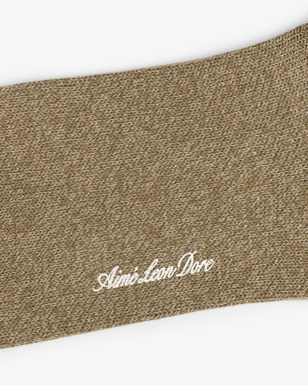 Close-up of brown knit Marled Quarter Sock with Aimé Leon Dore embroidered in white cursive.