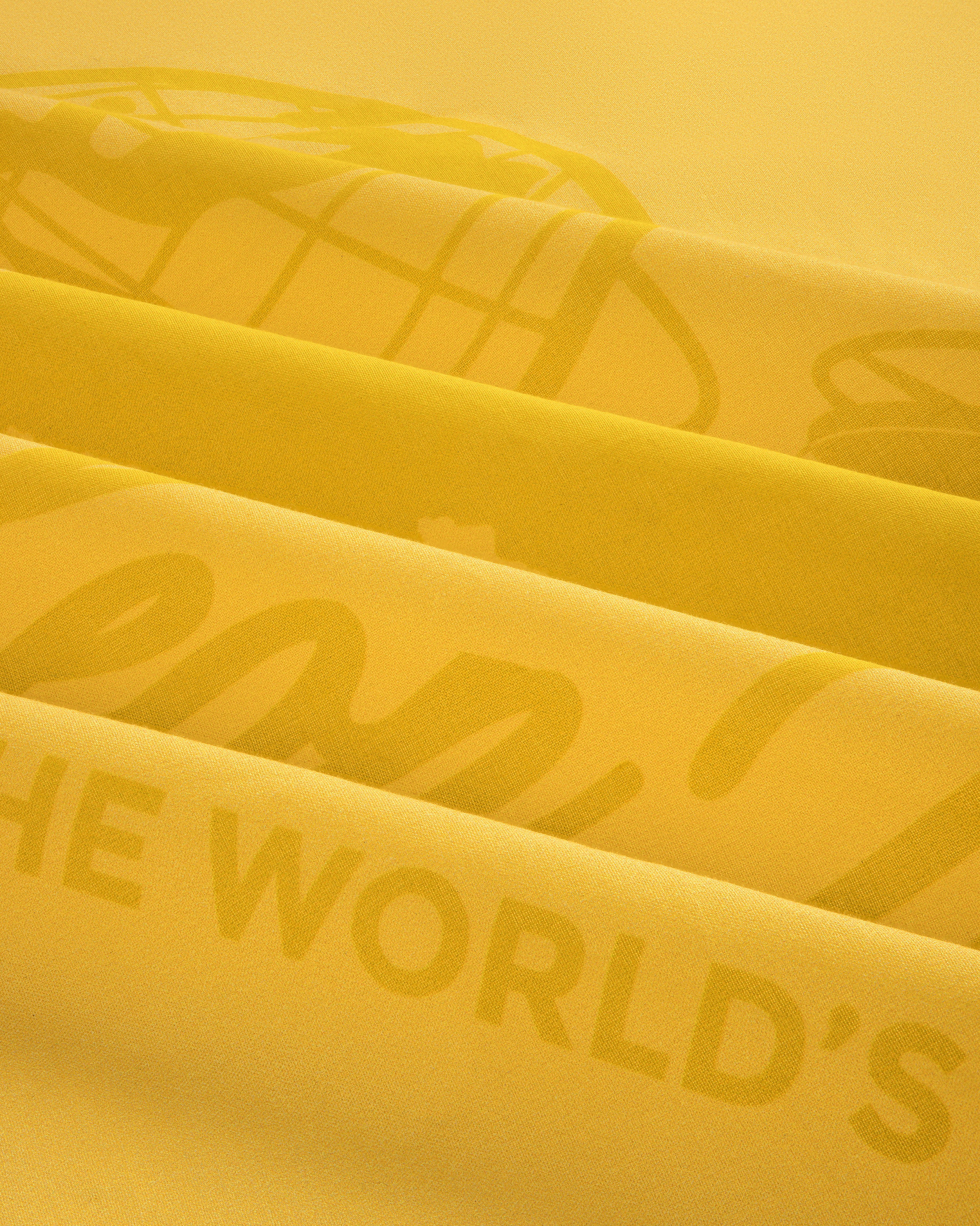 Close-up of the Sun Faded Unisphere Bandana's yellow fabric with layered printed text and graphics.
