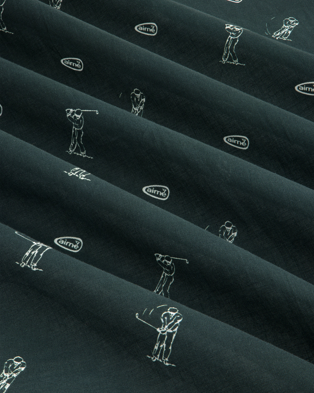 The ALD Golf Swing Bandana features dark fabric with white golfer sketches and airmx logos arranged diagonally.