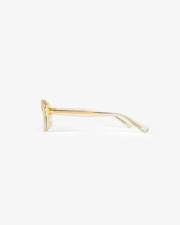 Side view of Onásis Sunglasses, transparent yellow with thick frames and straight arms on a white background.