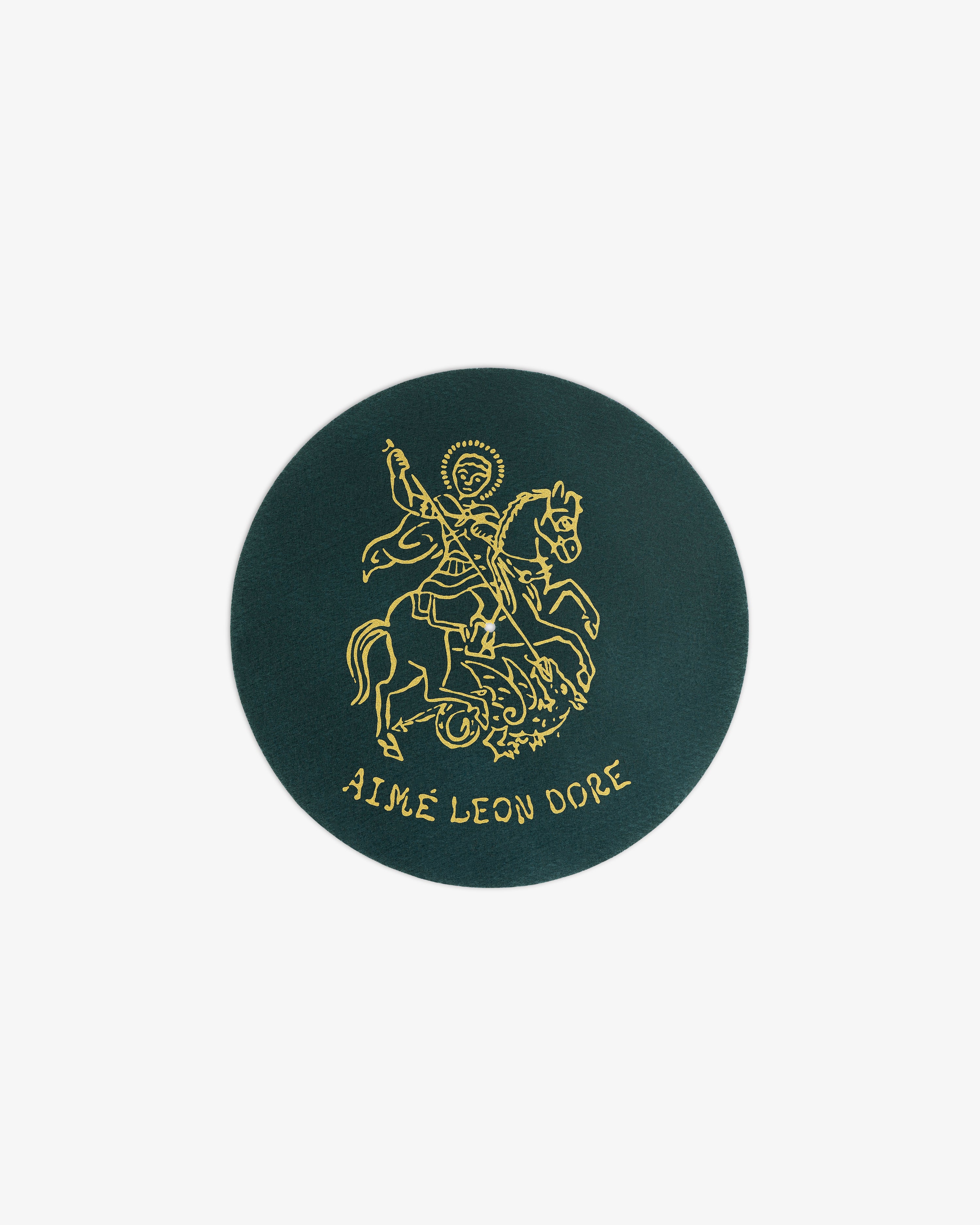 Dark green Graphic Slip Mat with a gold knight on horseback and AIMÉ LEON DORE text at the bottom.