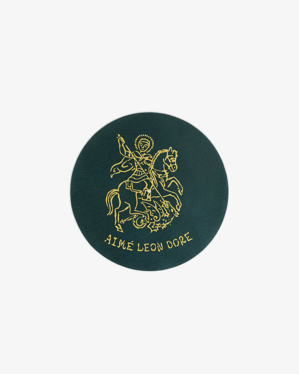 Dark green Graphic Slip Mat with a gold knight on horseback and AIMÉ LEON DORE text at the bottom.