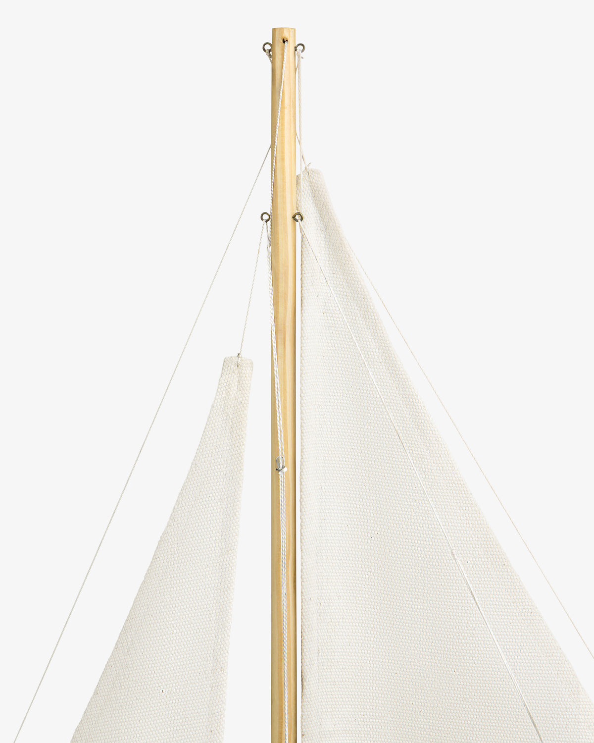 Close-up of the Walnut Model Sailboat’s mast and white sails set against a plain white background.