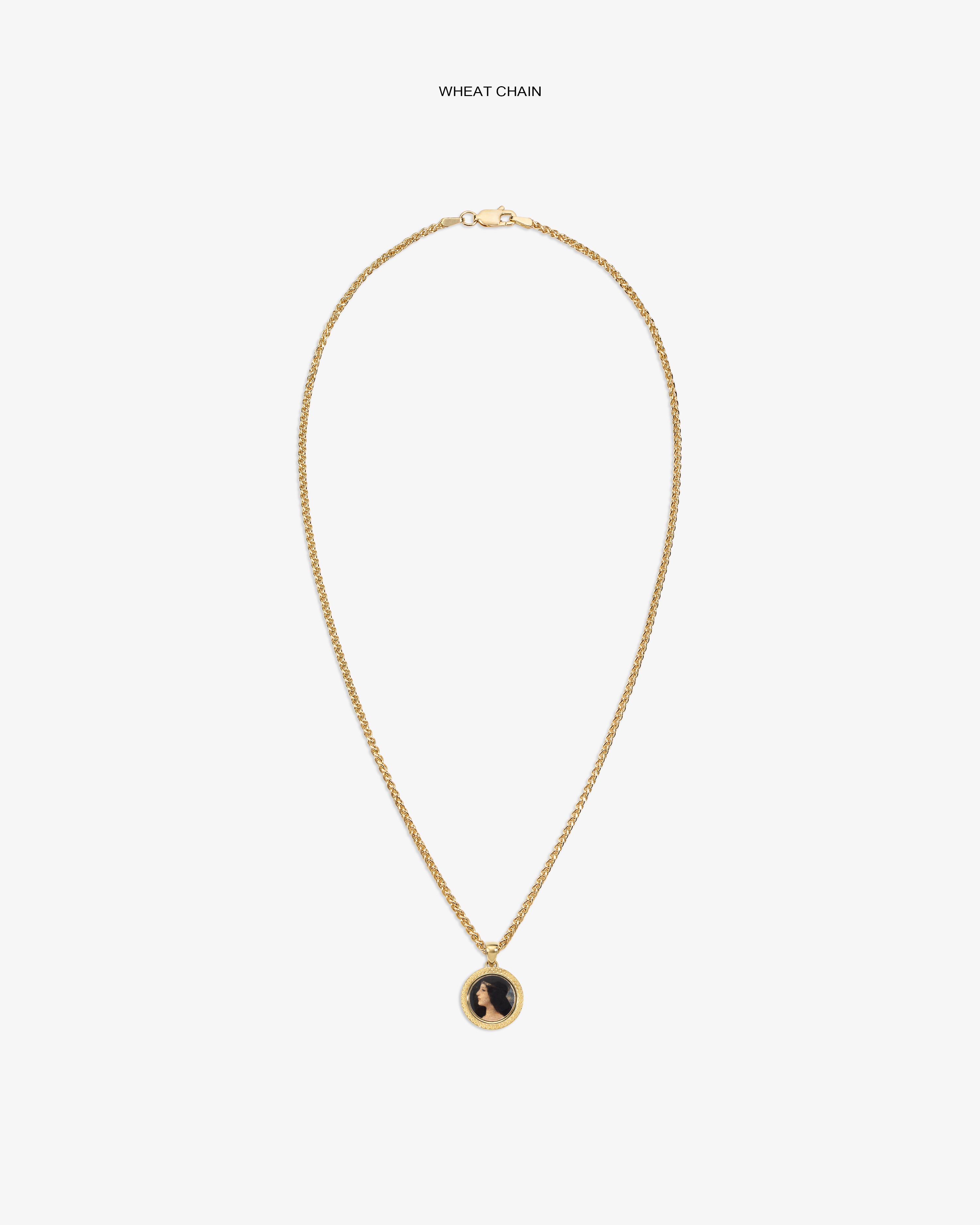 14Kt Gold Hera Pendant on a wheat chain with a black and gold round pendant, shown on a plain white background.