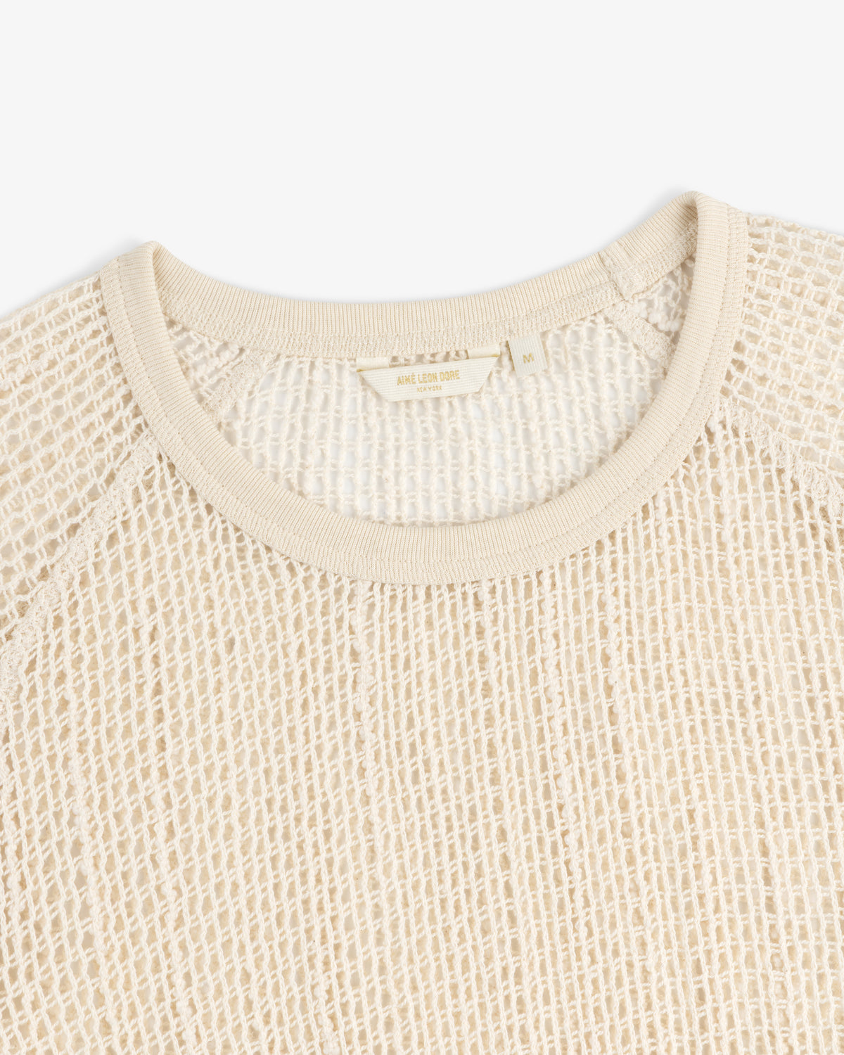 Close-up of an Open Mesh Mini Dress in beige featuring a round neckline and textured, grid-like pattern.