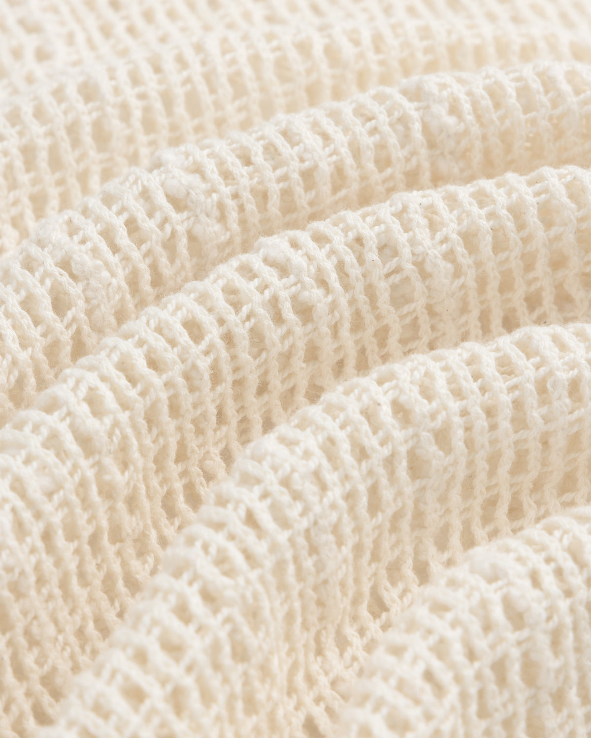 Close-up of the Open Mesh Mini Dress fabric, cream-colored with a soft waffle knit and textured grid pattern.