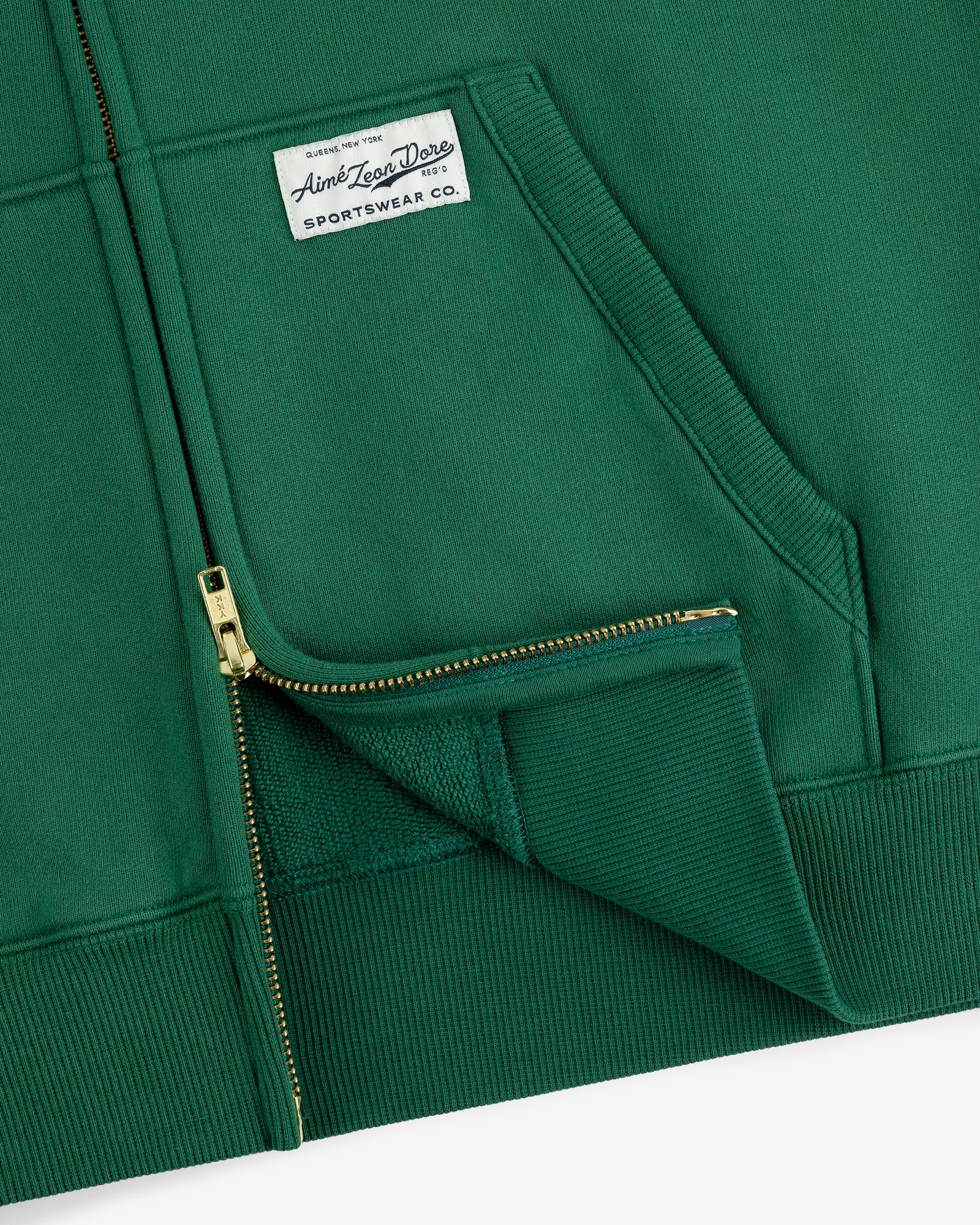 Sun Faded Full-Zip Hoodie in green with front pockets and a white Aimé Leon Dore patch on the left chest.
