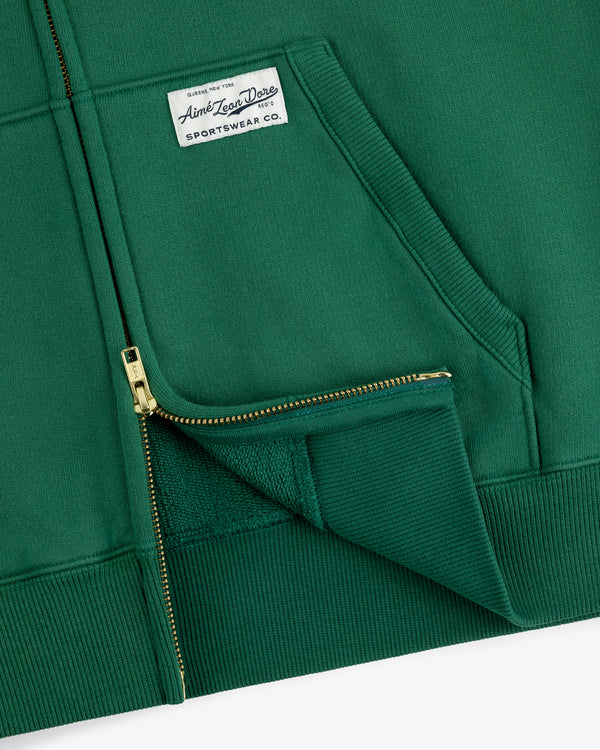 Sun Faded Full-Zip Hoodie in green with front pockets and a white Aimé Leon Dore patch on the left chest.