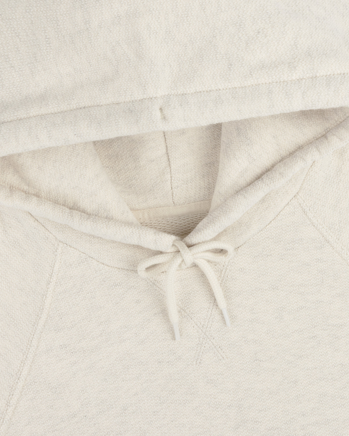 Close-up of the Dock Hoodie in cream, highlighting the hood, drawstrings, and neckline.