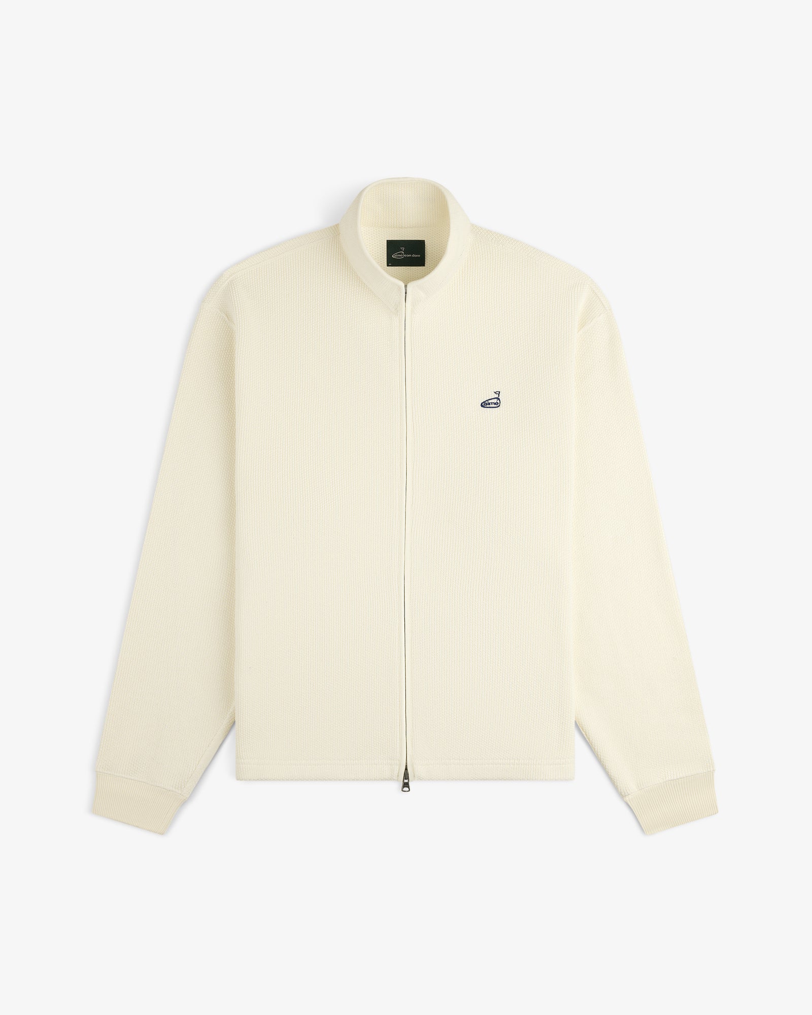 ALD Golf Piqué Full Zip Sweater in off-white with ribbed texture and small left chest logo, shown laid flat on white.