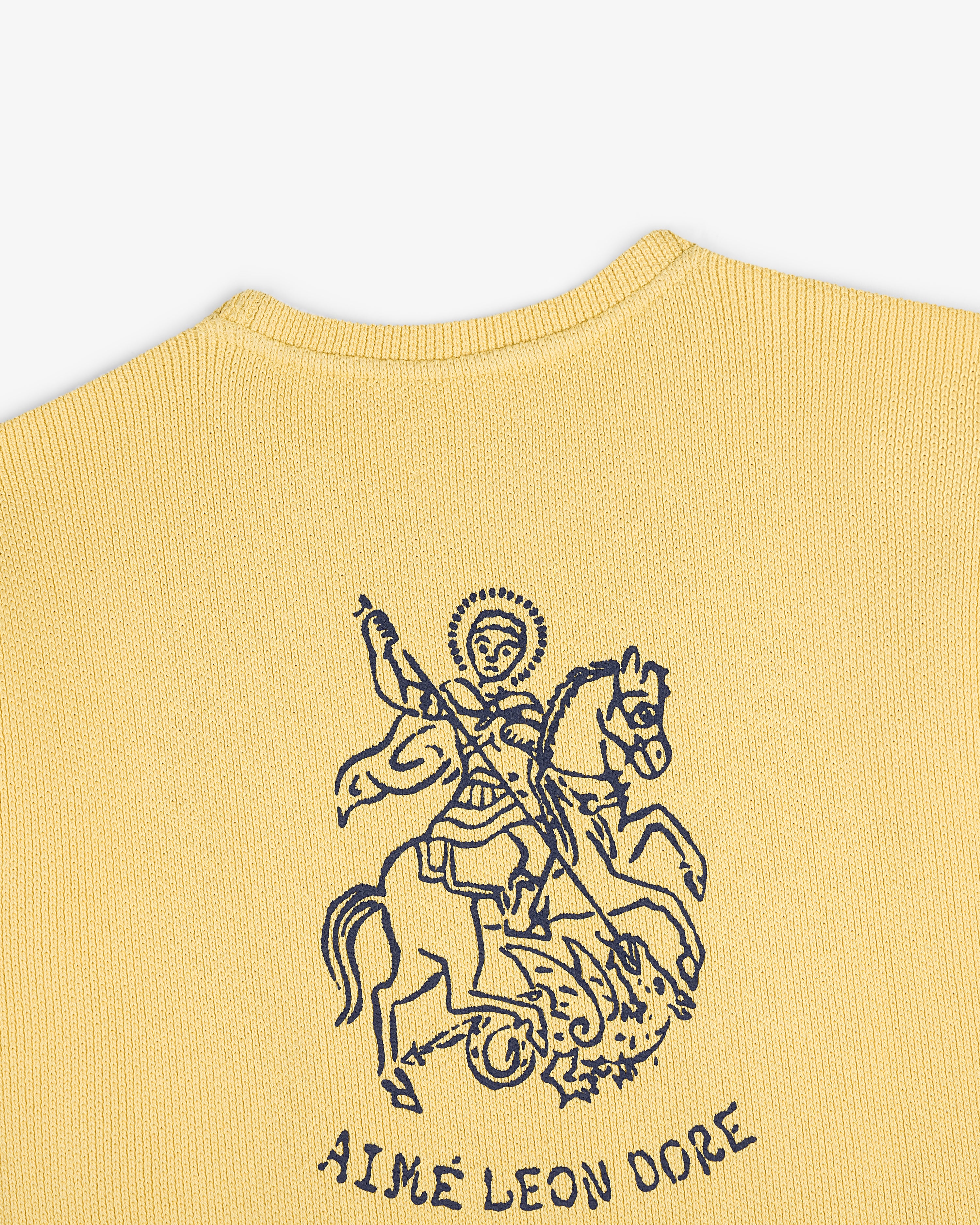 Yellow knit Saint George Piqué Crewneck Sweatshirt with dark blue line art and Aimé Leon Dore text below.