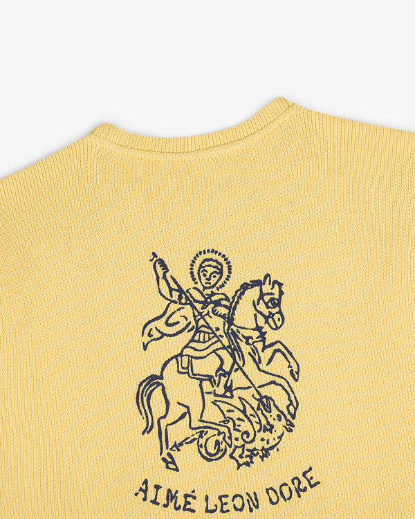 Yellow knit Saint George Piqué Crewneck Sweatshirt with dark blue line art and Aimé Leon Dore text below.