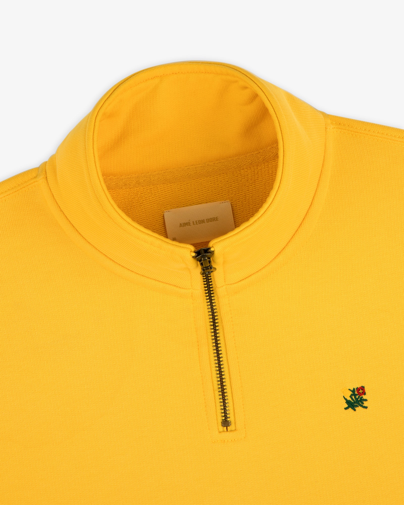 Sun Faded Crest Quarter Zip: Yellow pullover with standing collar, green and red embroidered logo on the chest.