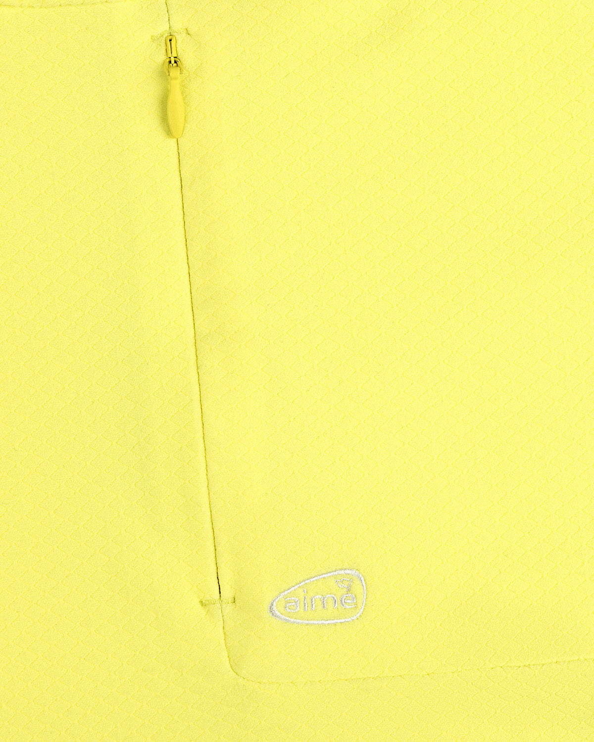 Close-up of ALD Golf Quarter Zip Pullover in yellow with textured fabric, zip pocket, and embroidered white aimé logo.