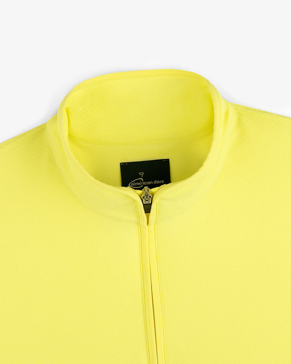 Close-up of the ALD Golf Quarter Zip Pullover in bright yellow with a stand collar and black label at the neckline.