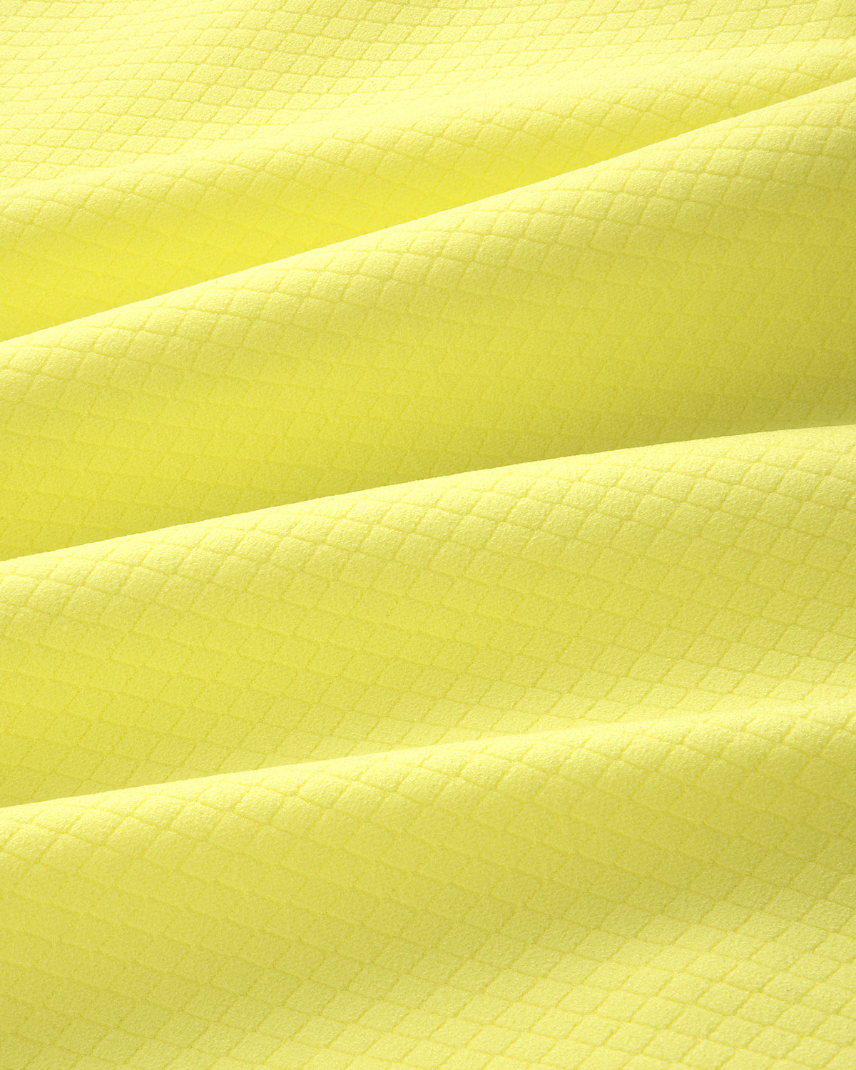 Close-up of the ALD Golf Quarter Zip Pullover's yellow textured fabric with a subtle diamond pattern and soft folds.