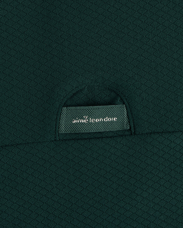 Close-up of textured dark green ALD Golf Quarter Zip Pullover with label partially visible in the pocket.