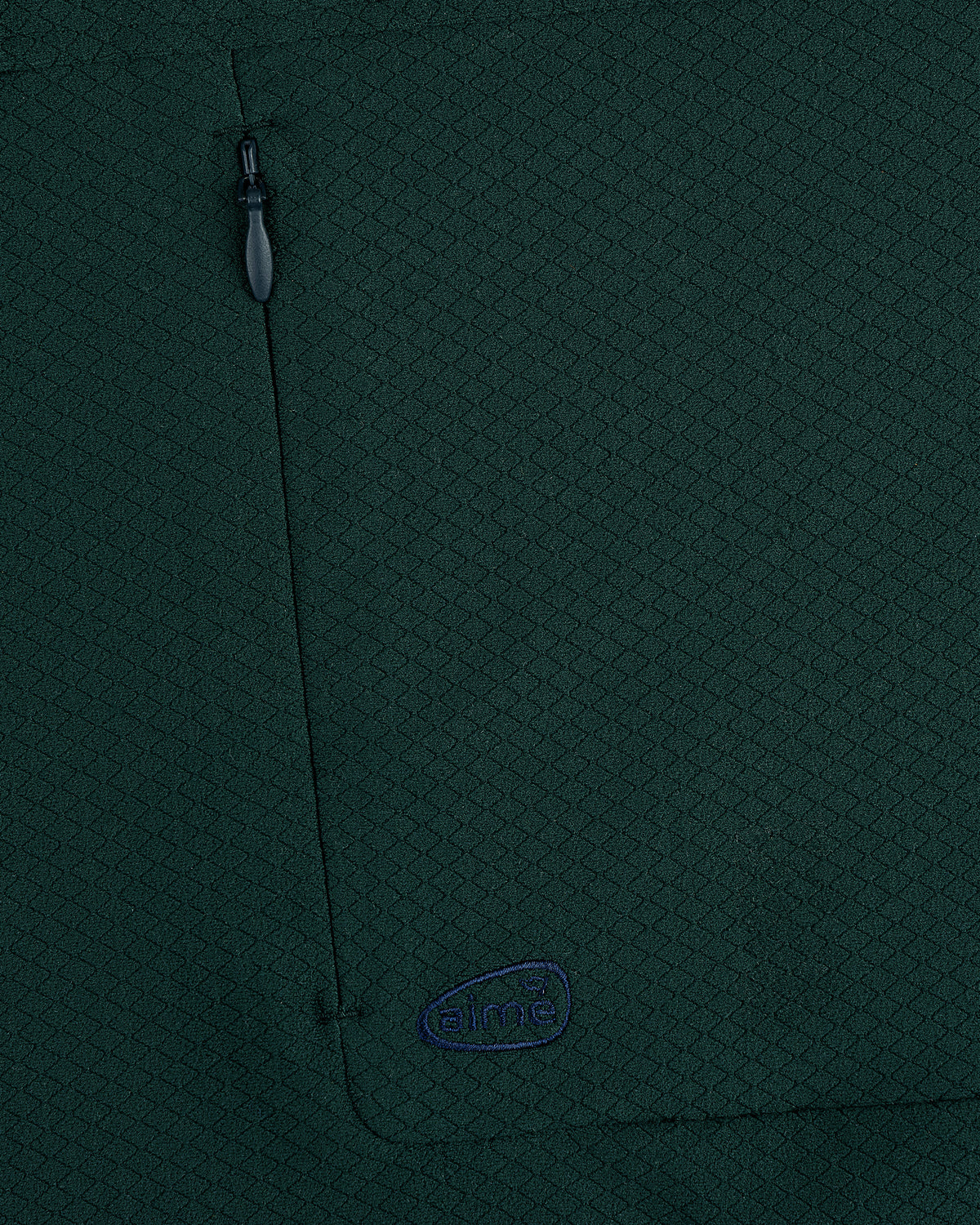 Close-up of ALD Golf Quarter Zip Pullover in dark green with textured fabric, zippered pocket, and small embroidered logo.
