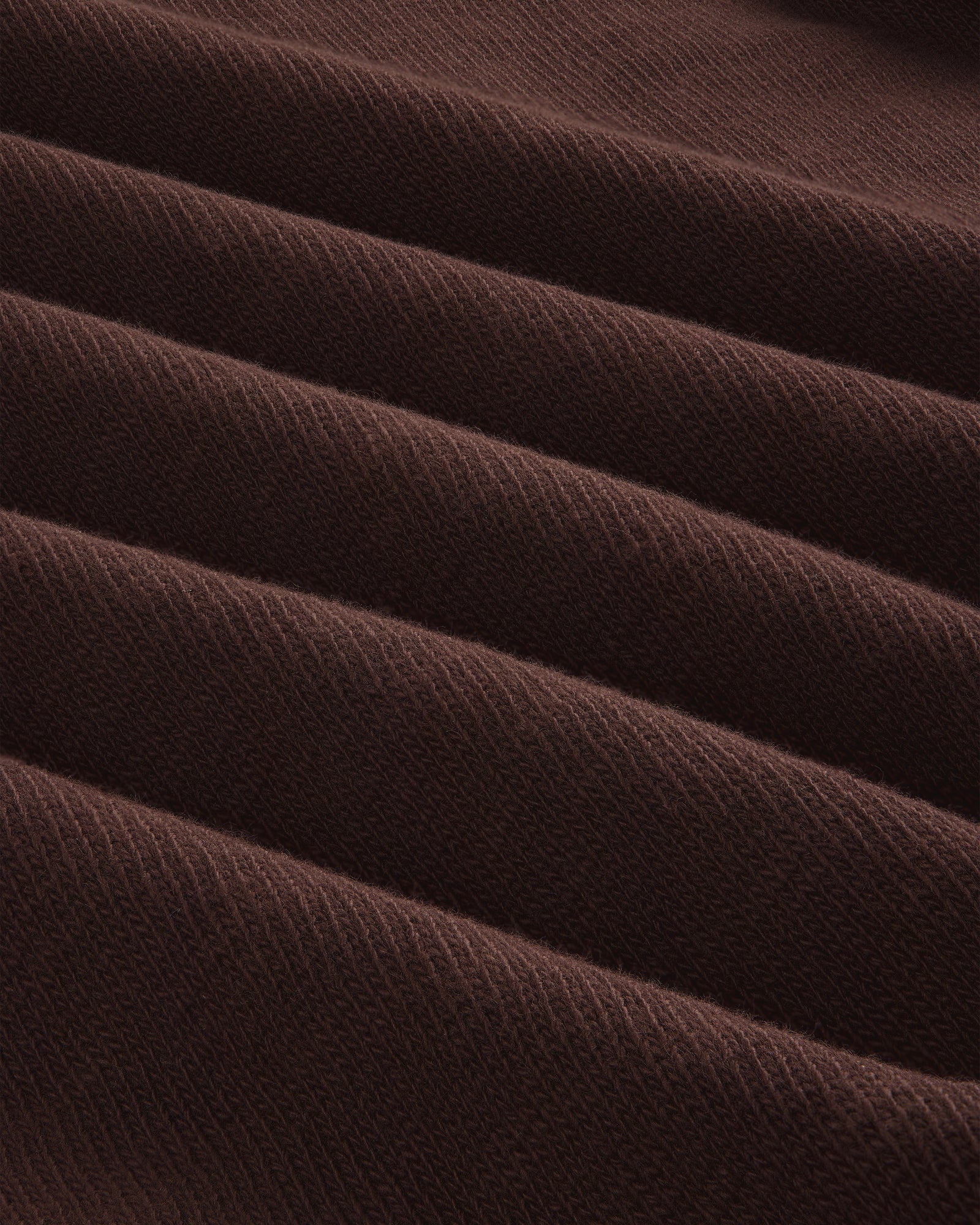 Close-up of Long-Sleeve Slub Football Tee in dark brown, showing ribbed fabric with diagonal texture and repeating ridges.