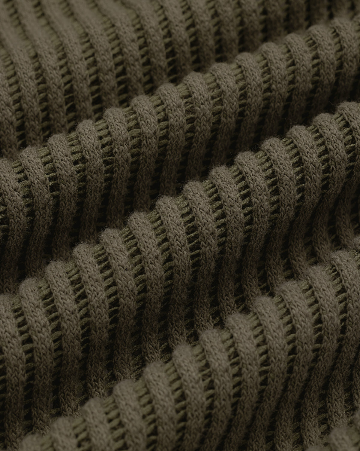 Close-up of olive green ribbed knit on the Mesh V-Neck Tee, showing horizontal ridges and textured detail.