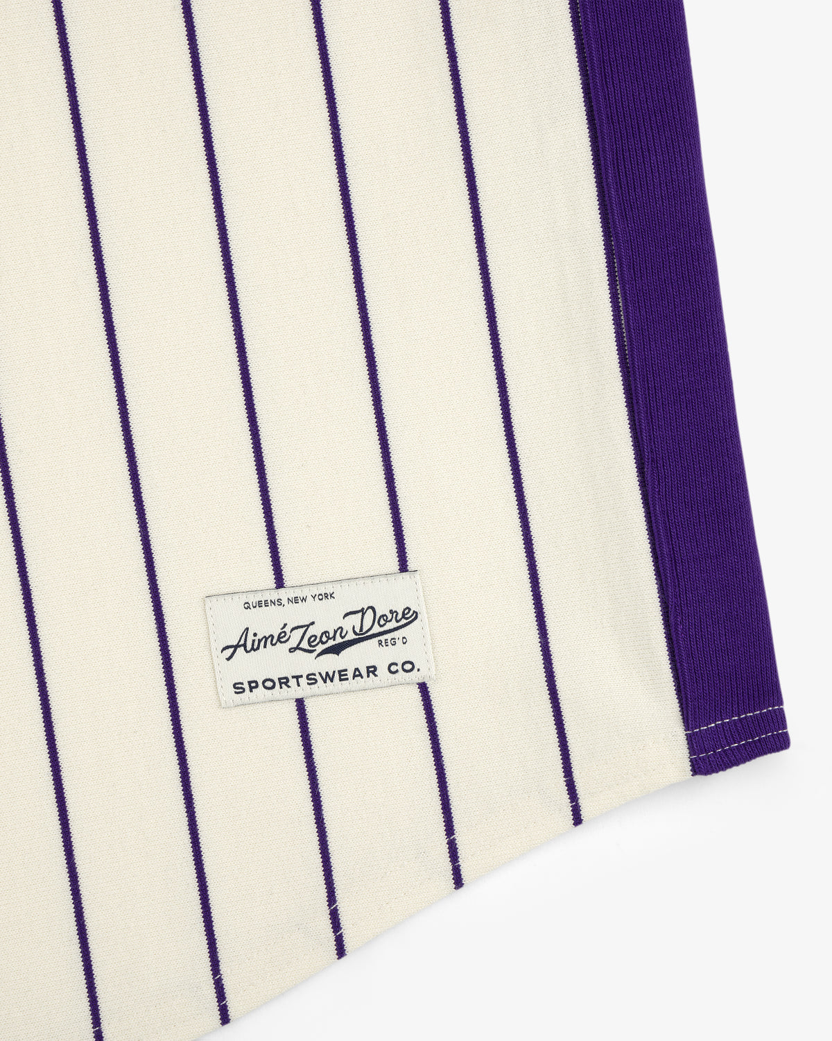 Cream Aimé Baseball Jersey with thin purple stripes and a black "Aime Leon Dore SPORTWEAR CO." sewn label.