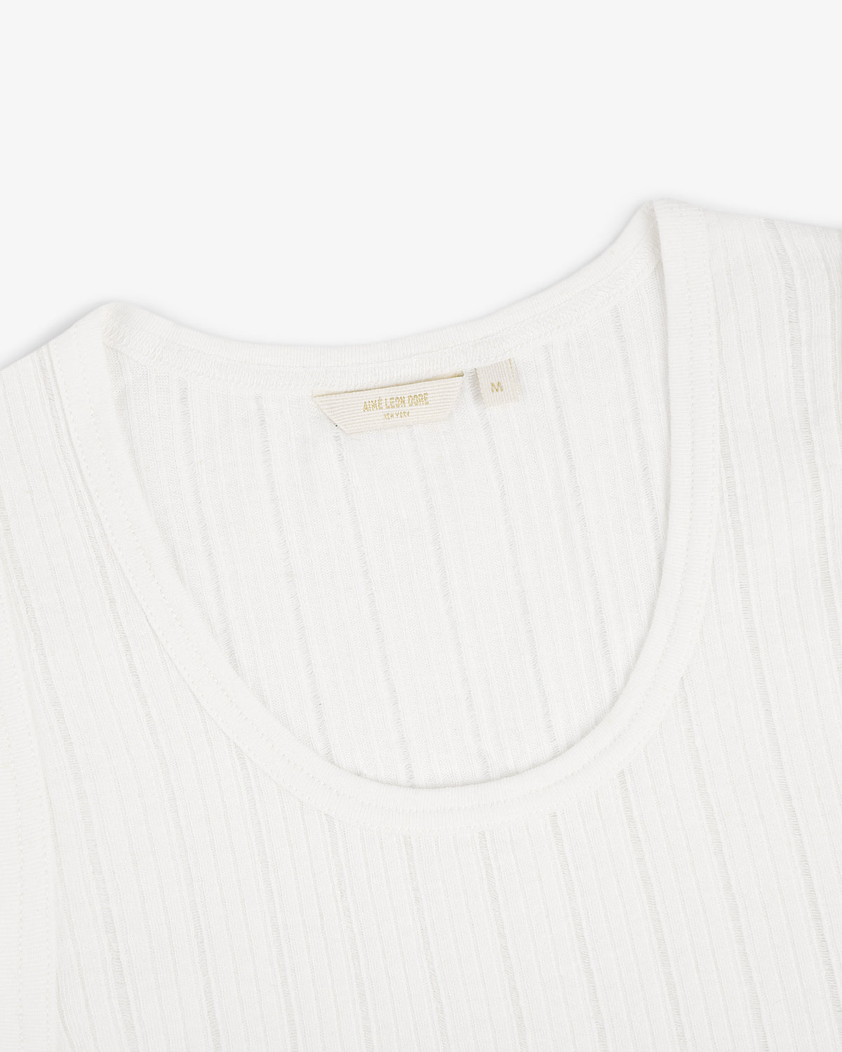 Close-up of a Drop Needle Tank Top with a fabric label inside the collar, photographed on a white background.