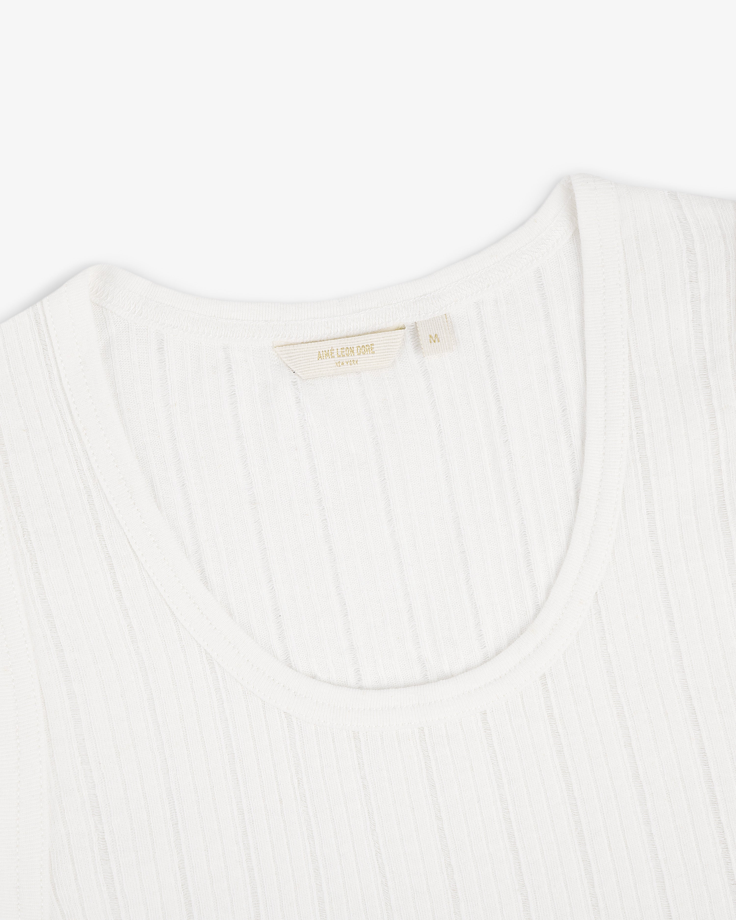 Close-up of a Drop Needle Tank Top with a fabric label inside the collar, photographed on a white background.