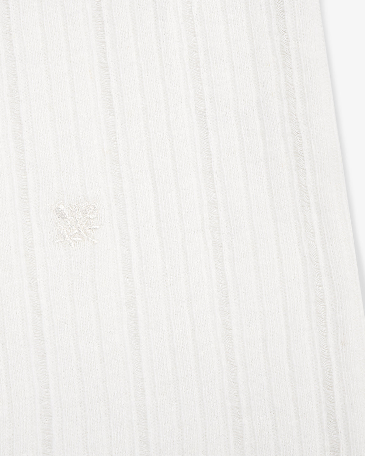 Close-up of the Drop Needle Tank Top's white ribbed fabric with subtle vertical stripes and a central embroidered emblem.