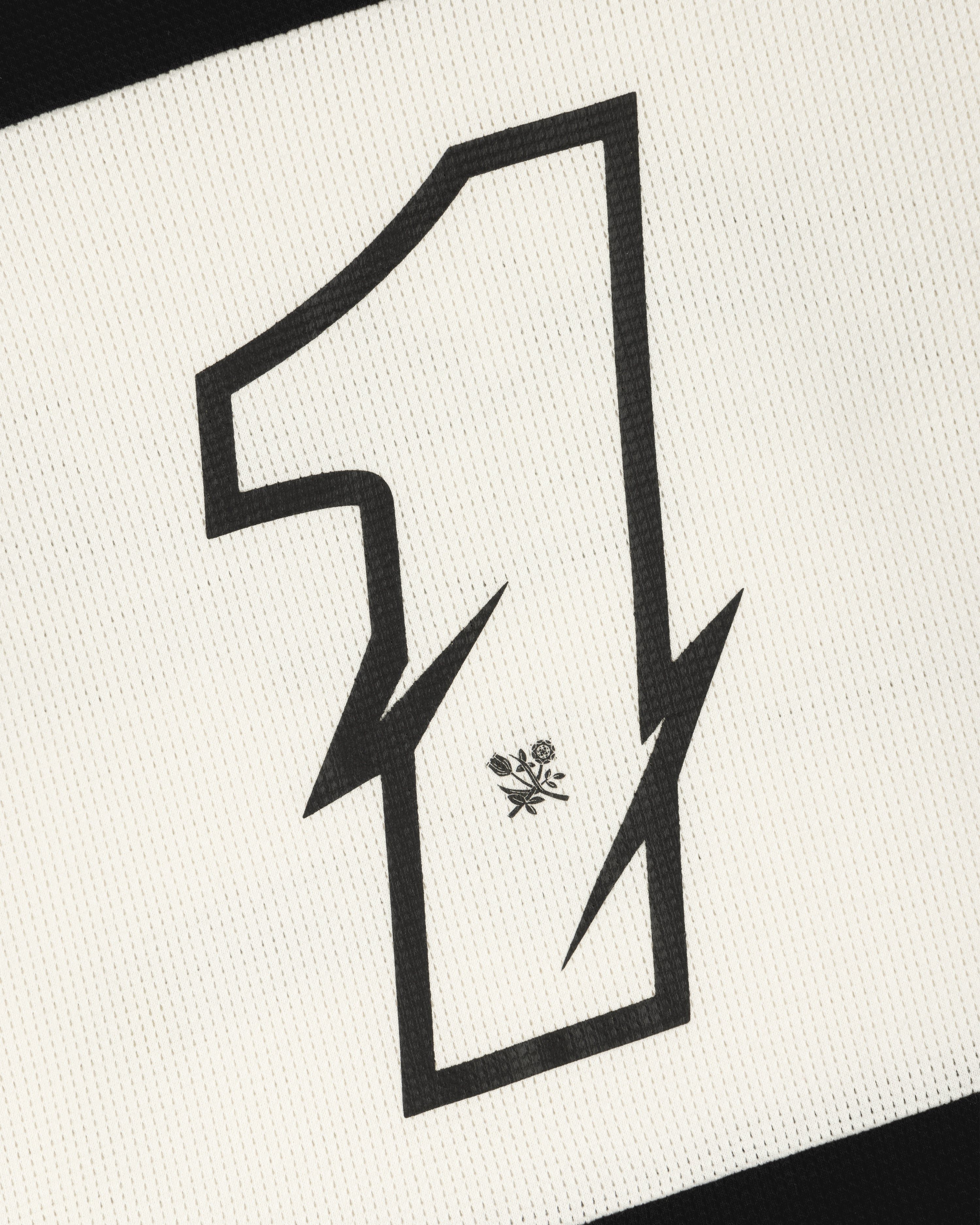 A bold, black number 1 with zigzag edges and a flower sits on the Long-Sleeve Mesh Enduro Tee’s textured white fabric.