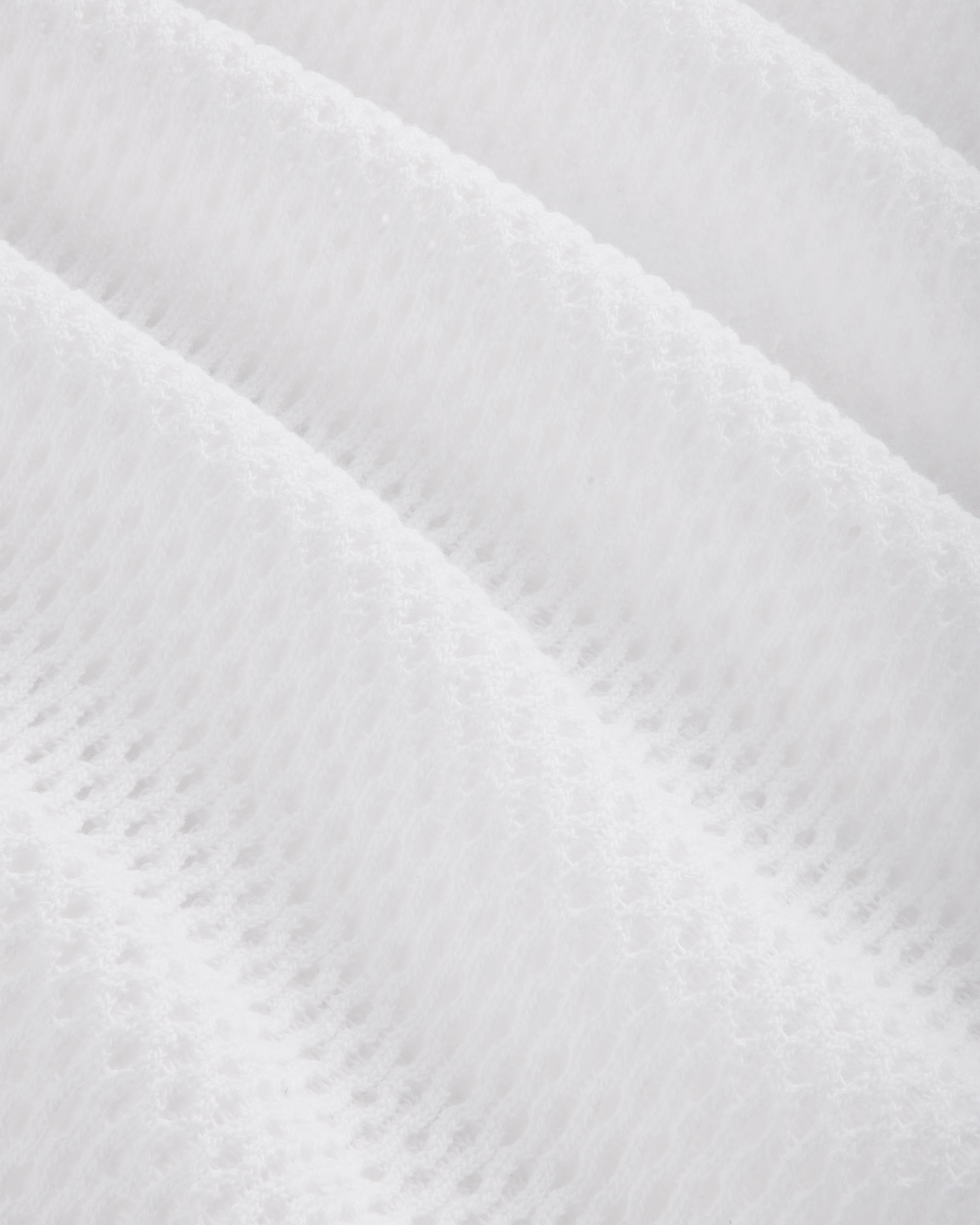 Close-up of the Mesh Tank Top's white textured fabric featuring a soft, quilted, diagonal wavy pattern.