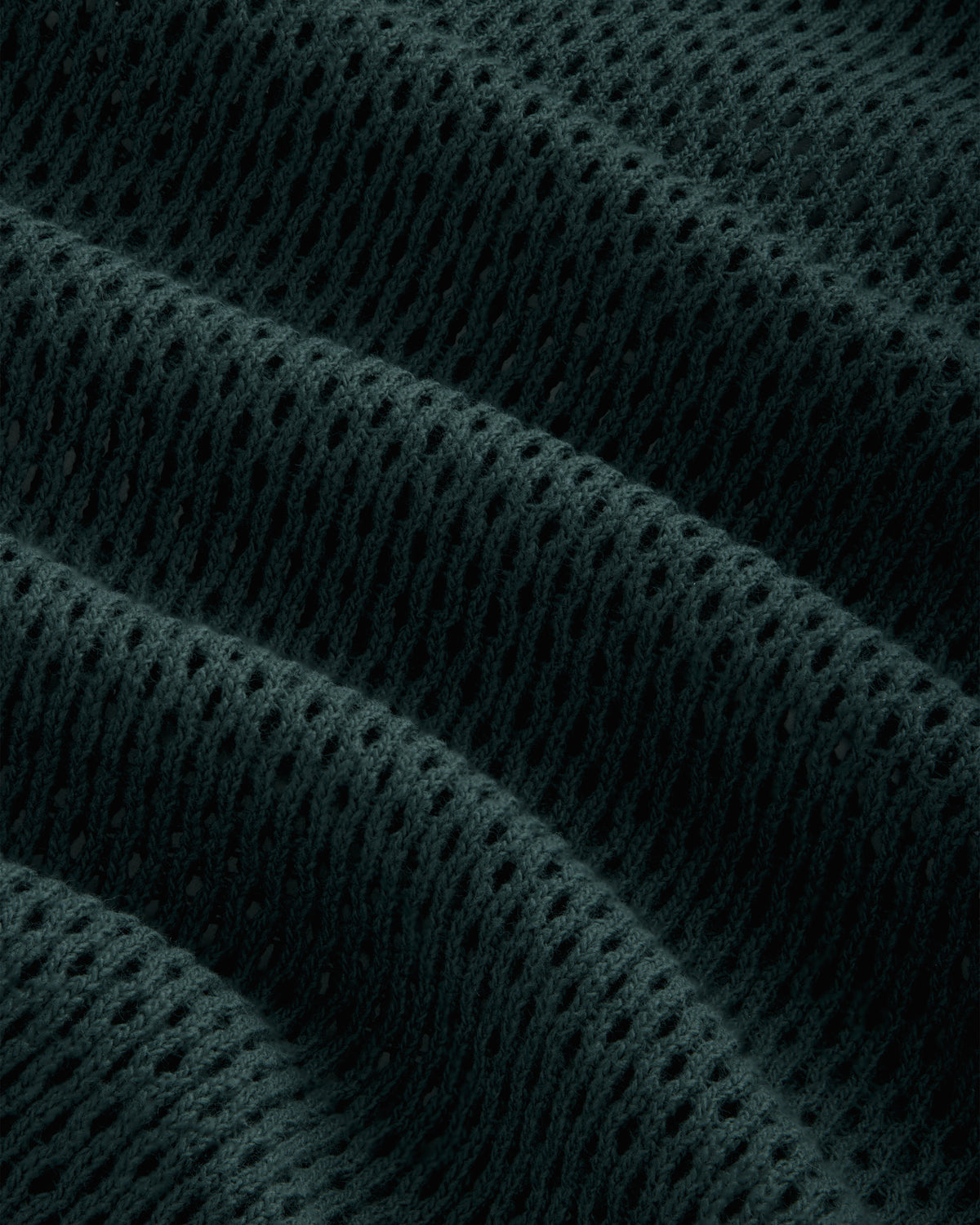 Close-up of Mesh Tank Top fabric featuring dark, textured mesh with raised wavy ridges and small, even holes.