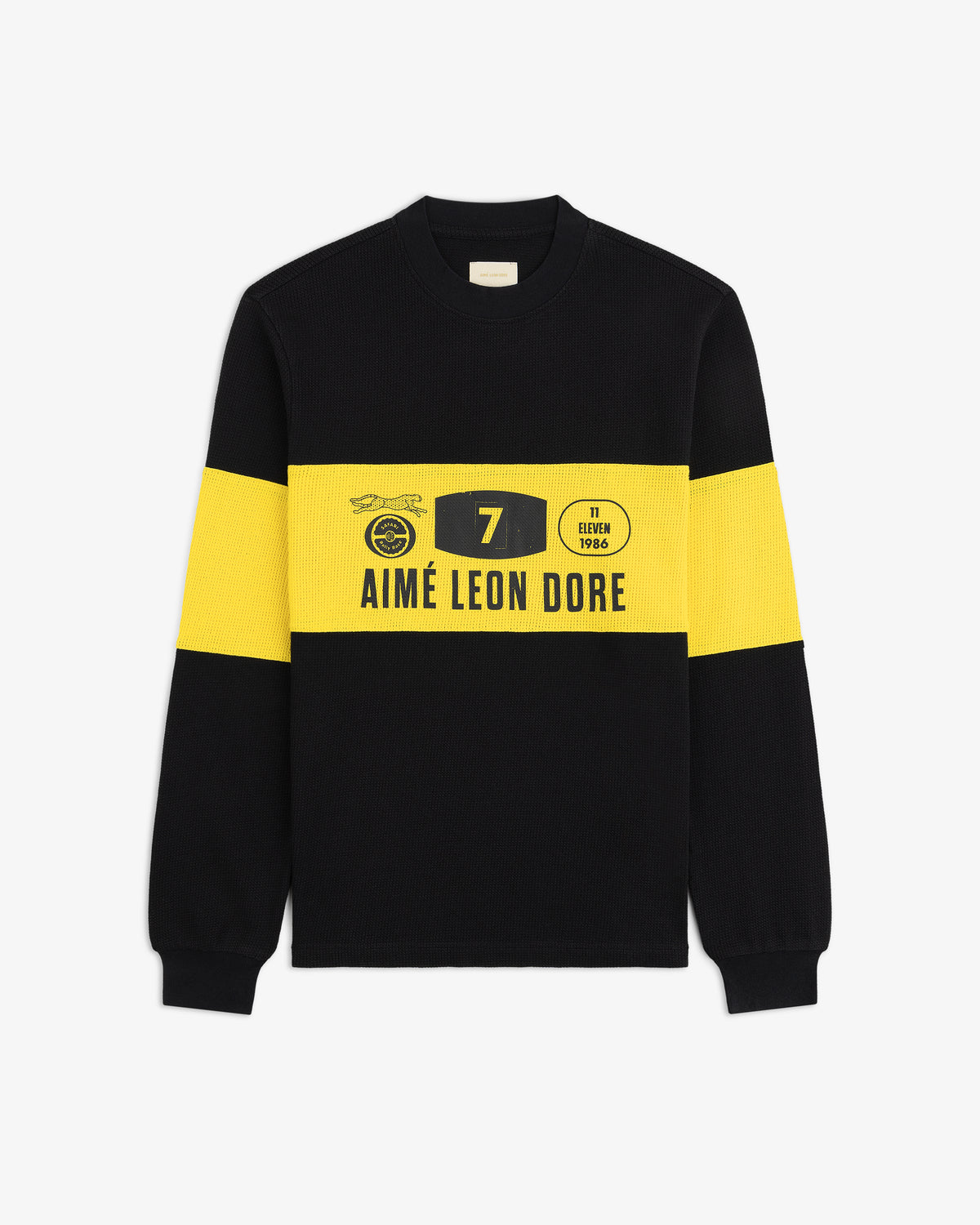 The Long-Sleeve Rally Tee is black with bold yellow bands and Aimé Leon Dore logo and graphics on the front.