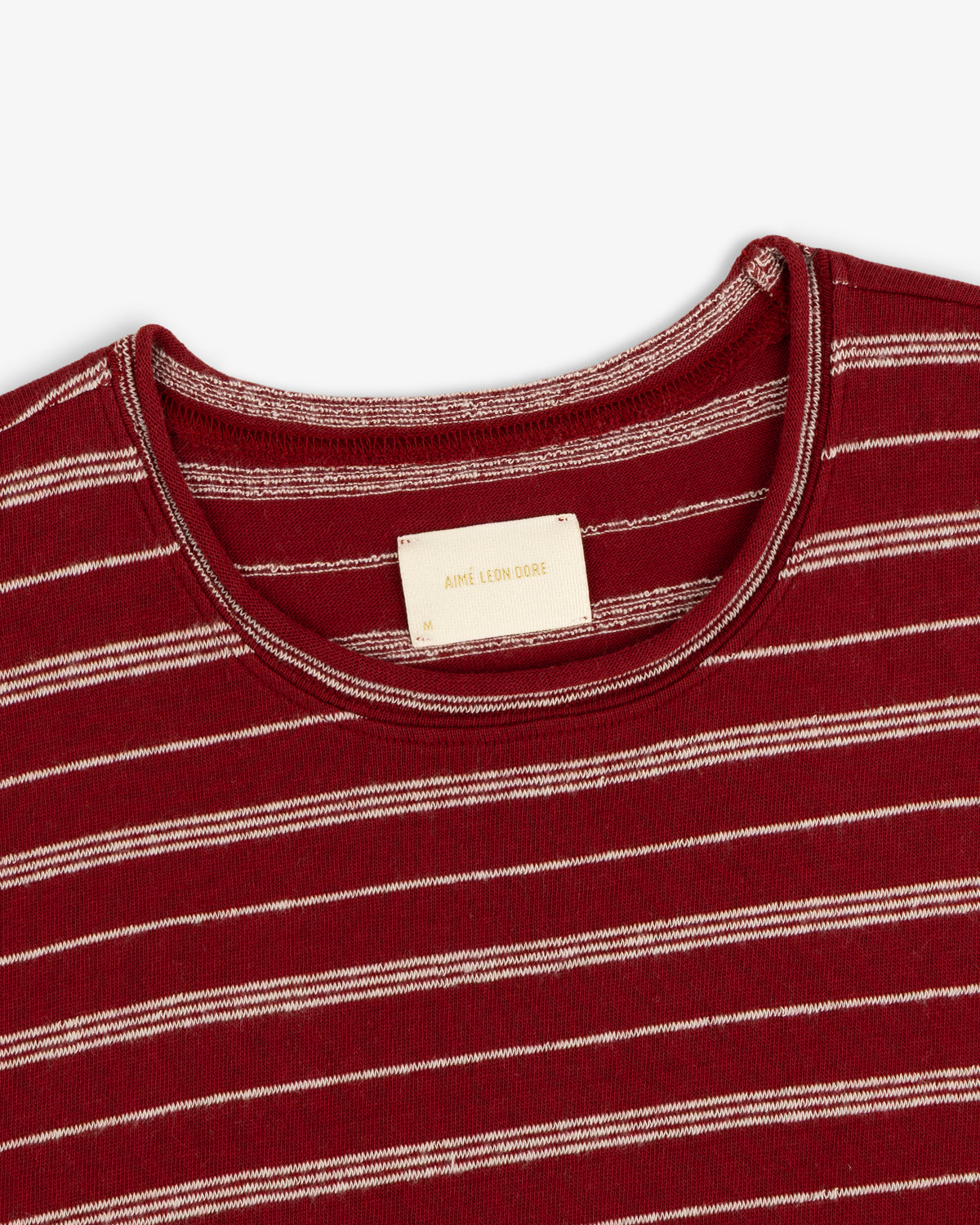Close-up of a Jacquard Striped Rollneck Tee featuring red and white stripes and a beige label inside the collar.