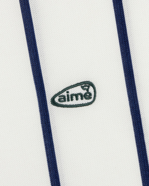 The ALD Golf Polo features white fabric with vertical navy stripes and a small green aimé logo embroidered at the center.