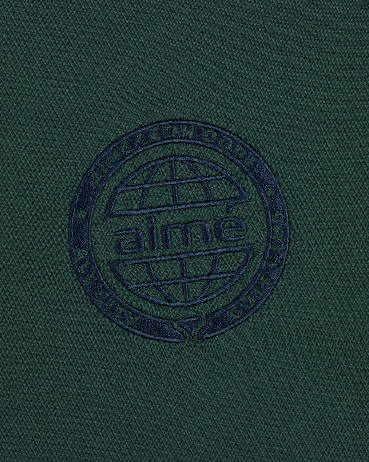 Dark green ALD Golf Tour Polo with a navy globe logo and "Aimé Leon Dore All City Golf Club" circle embroidery.