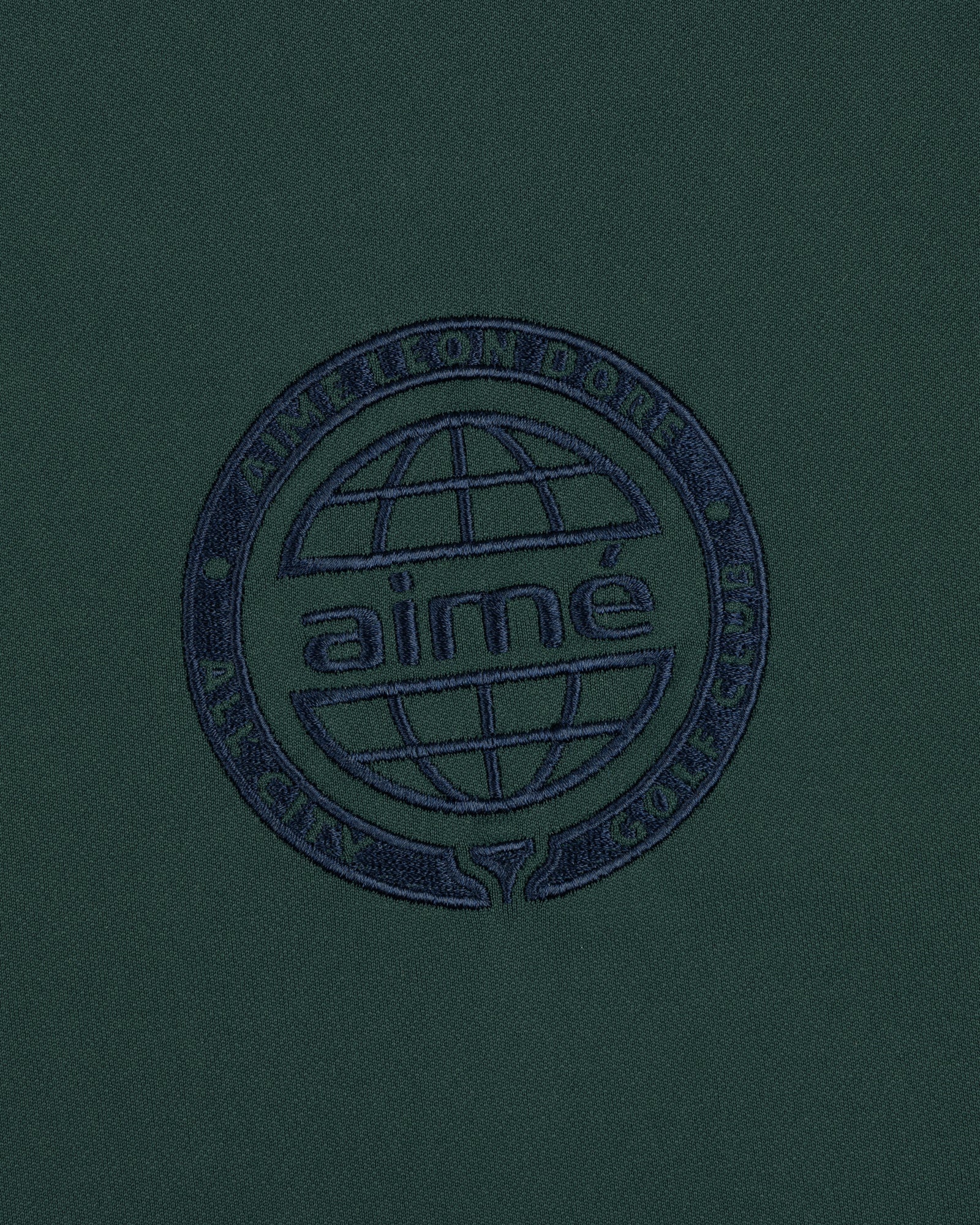 Dark green ALD Golf Tour Polo with a navy globe logo and "Aimé Leon Dore All City Golf Club" circle embroidery.