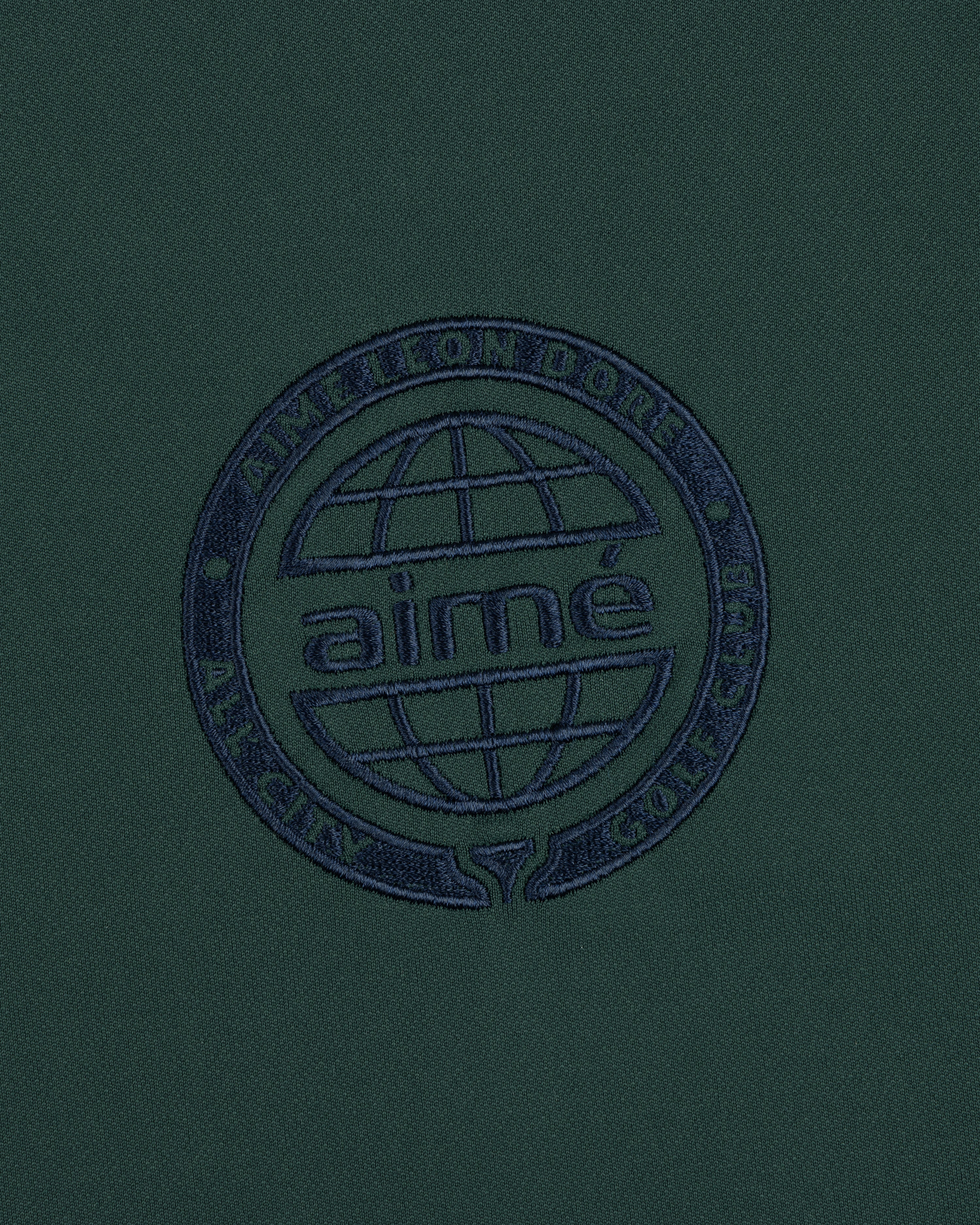 Dark green ALD Golf Tour Polo with a navy globe logo and "Aimé Leon Dore All City Golf Club" circle embroidery.