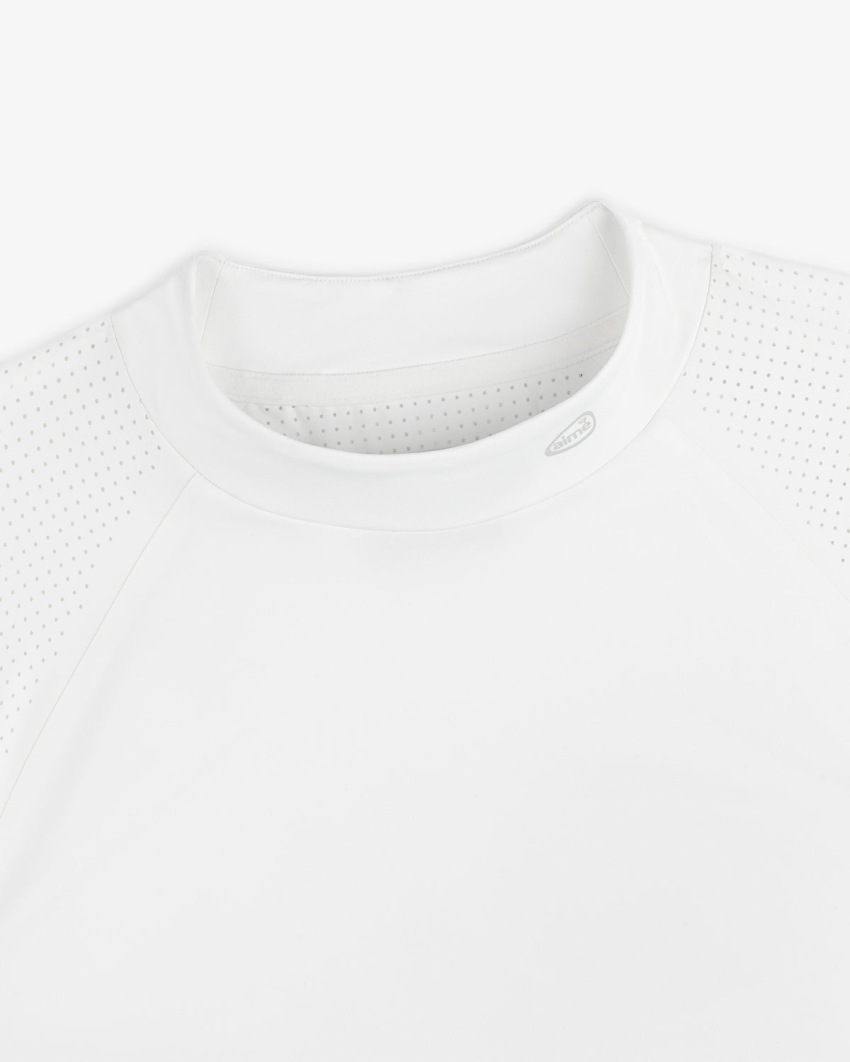Close-up of the ALD Golf Performance Tee, featuring perforated raglan sleeves and a crew neck on a white background.