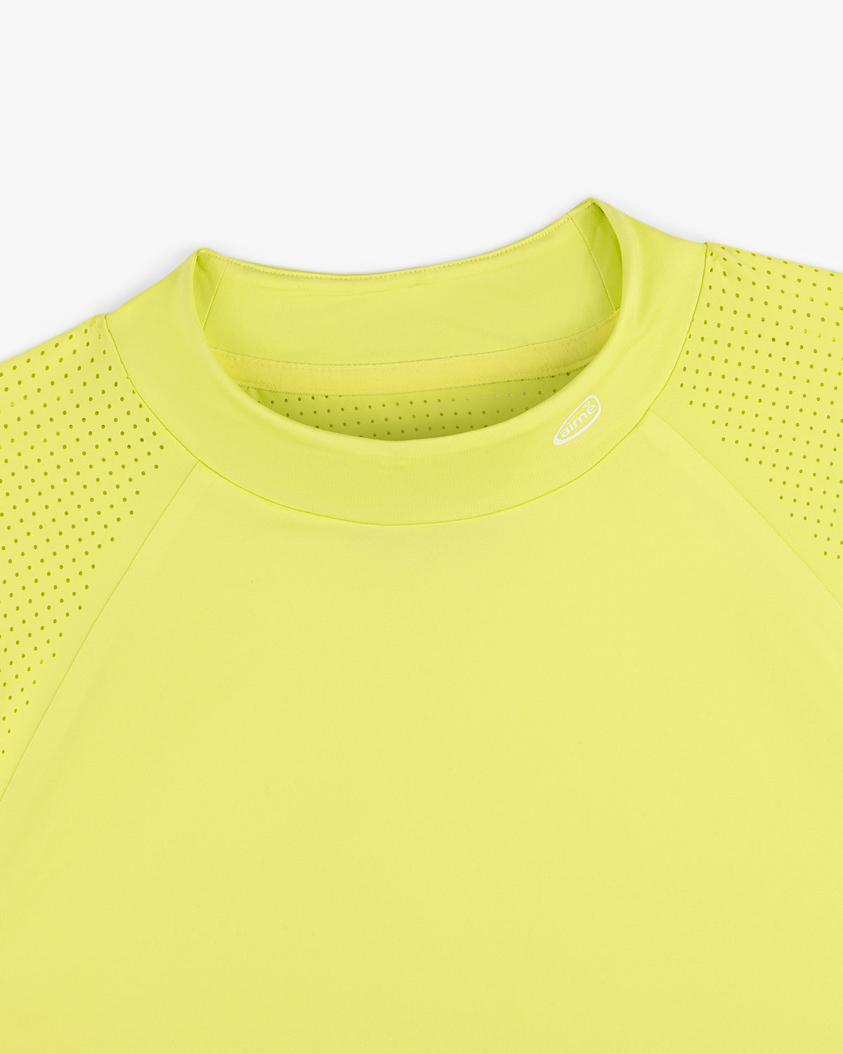 Close-up of the ALD Golf Performance Tee in yellow, featuring perforated sleeves and a round neck on white background.