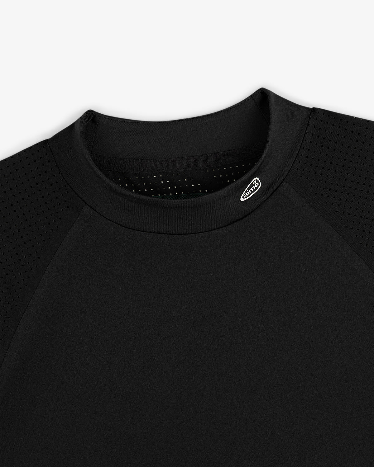 Close-up of the ALD Golf Performance Tee in black with perforated sleeves and a small logo near the collar.