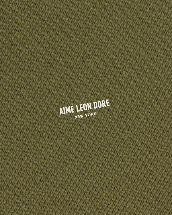 Olive green Safari Tee with small white AIMÉ LEON DORE NEW YORK text printed in the center.