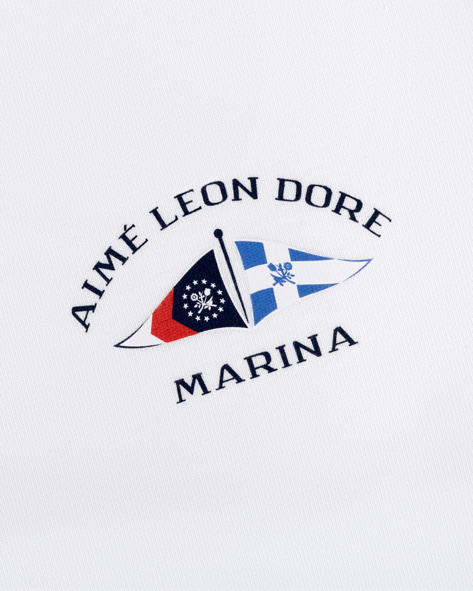 Marina Tee featuring embroidered Aimé Leon Dore Marina logo with two nautical flags on a white background.