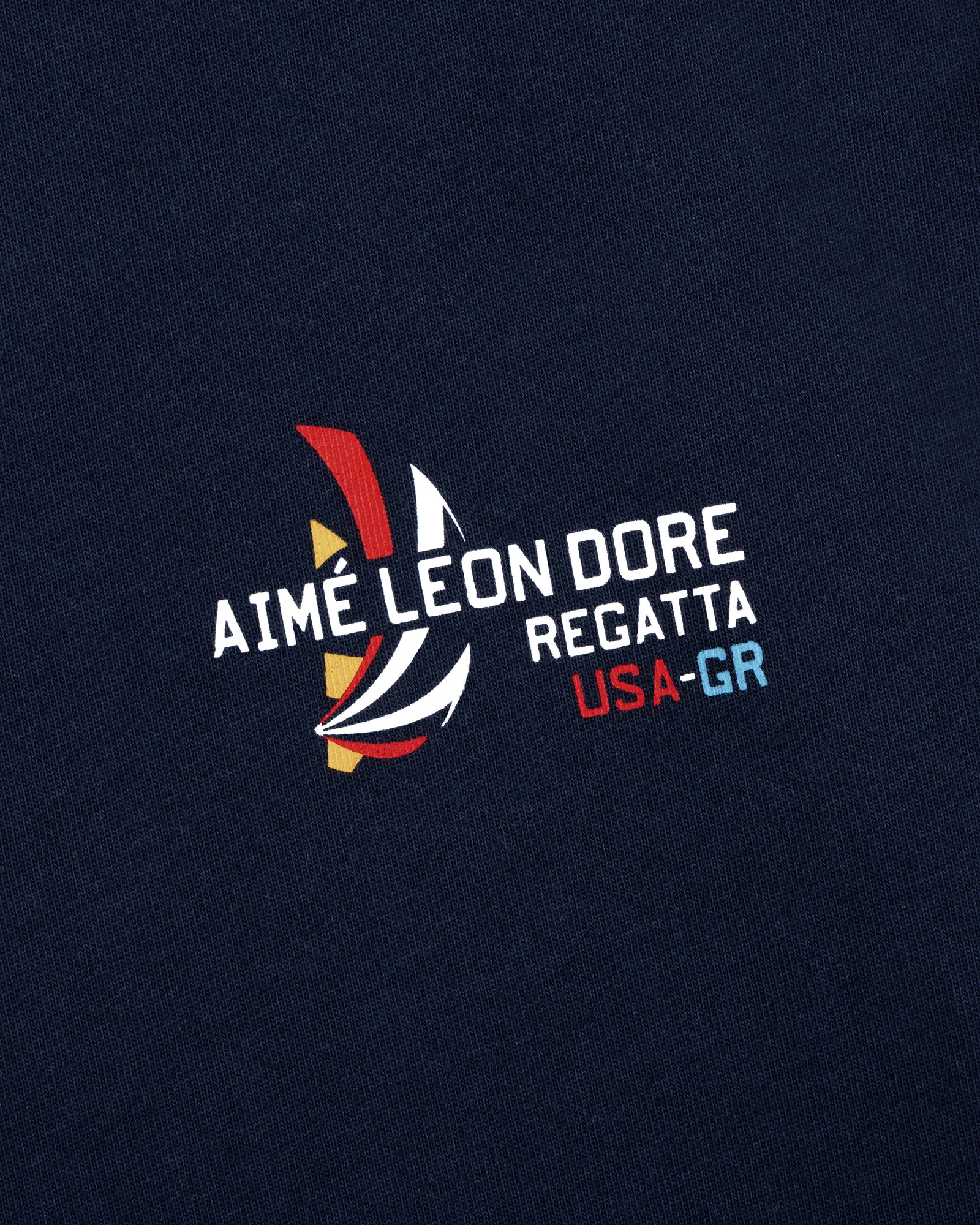 Regatta Tee in navy with AIMÉ LEON DORE REGATTA USA-GR and colorful abstract sailboat graphic print.