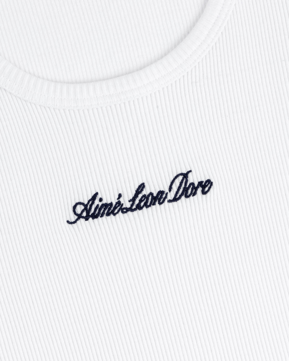 Close-up of a white ribbed Embroidered Logo Tank Top with Aimé Leon Dore in black cursive lettering.