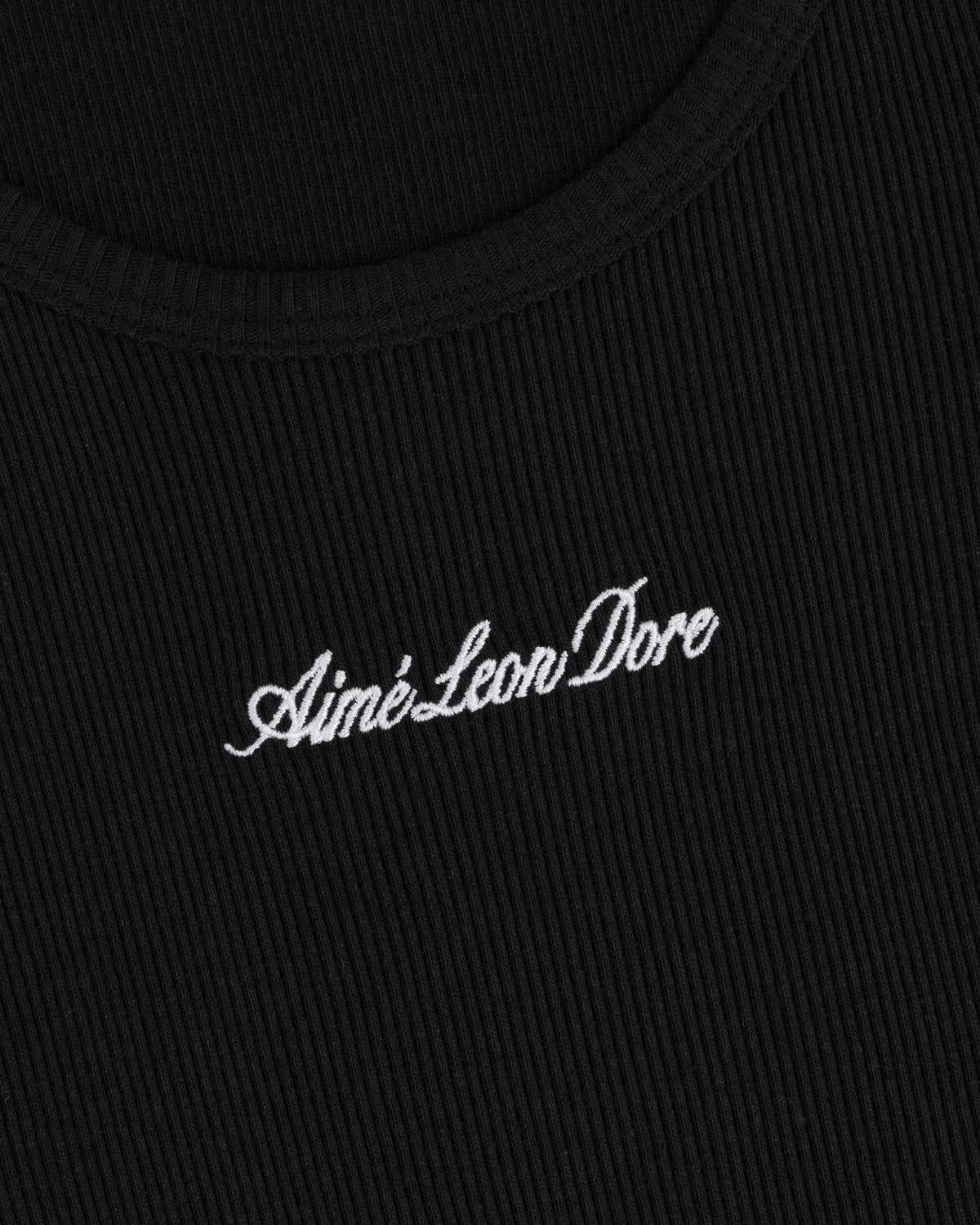 Close-up of black ribbed Embroidered Logo Tank Top with “Aimé Leon Dore” in white cursive embroidery.